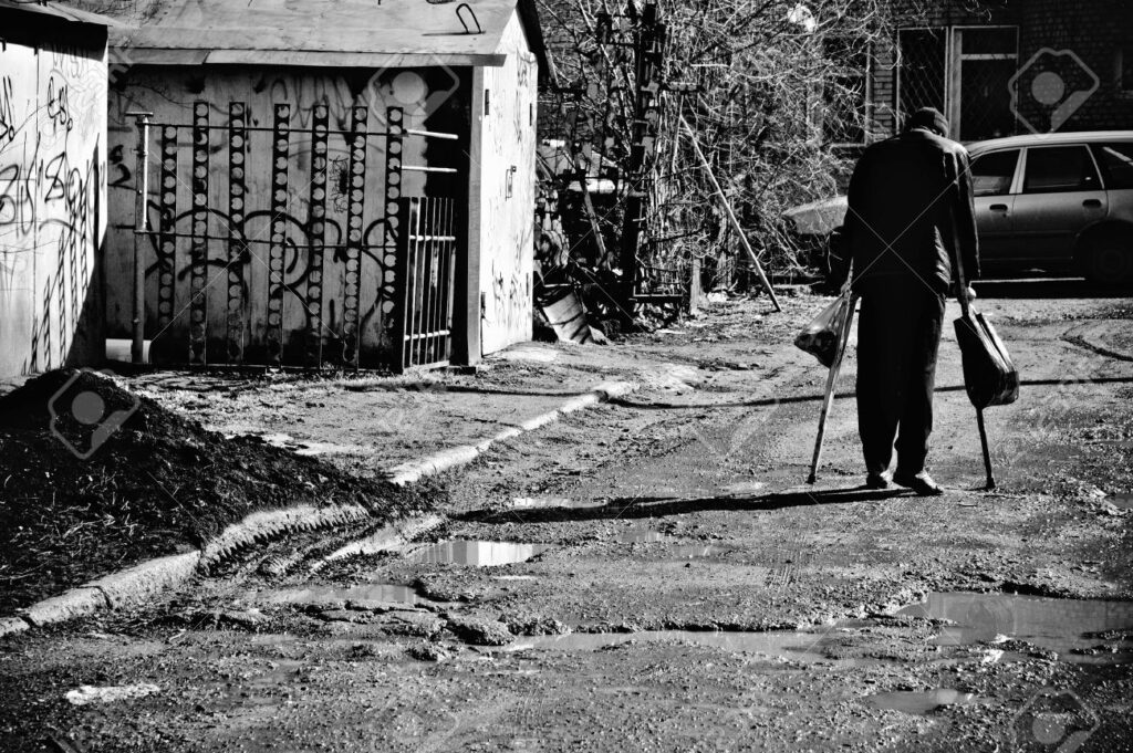 Old Uncle Willie And The Need To Feel Normal When Nothing Is Normal 7 9489303 A Sick Poor Man With Crutches Walking Down The Street Rear View Black And White